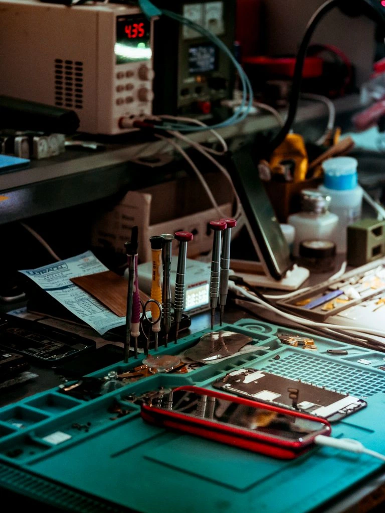 Disassembled smart speaker components laid out on a teardown workbench.